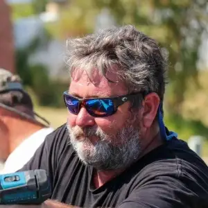 Profile headshot of Larry installing a seamless gutter.